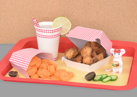 Rotes McDonald’s-Tablett mit gelber Unterlage, dekoriert mit einer Fimo-Maus in McDonald’s-Uniform, einem Royal-TS-Burger aus Modelliermasse, einer geöffneten Chicken-Box mit Hähnchenteilen, einem Pappbecher mit Wasser und einer Pommes-Box voller Karottenscheiben - detailreich arrangiert von Veronika Helga Vetter. GWS2.de - September 2025 Dieses Foto zeigt eine neue, humorvolle Szene auf dem vertrauten roten McDonald’s-Tablett mit sonnengelber Unterlage. Im Hintergrund die warme braune Korkplatte, im Vordergrund der freigestellte graue Rand - doch was sich darauf entfaltet, ist ein kleines Fast-Food-Märchen. Ganz rechts steht Gustl von Mausbach, eine weiße Fimo-Maus, die wie ein McDonald’s-Mitarbeiter gekleidet ist. Seine rote Schirmmütze trägt stolz das goldene M, und in beiden Händen balanciert er zwei detailgetreu modellierte Burger. Es handelt sich um königliche Royal-TS-Varianten mit großem Patty, Tomate und Käse - so echt, dass man fast den Duft frischer Burger vermuten möchte. Links daneben findet sich die vertraute 4er-Chicken-McNuggets-Box, geöffnet und gefüllt mit selbst ausgebackenen, goldbraun panierten Hähnchenteilen. Direkt daneben erhebt sich der weiße Pappbecher, mit Wasser gefüllt, samt Papierstrohhalm und frischer Limonenscheibe am Rand - ein Hauch Erfrischung mitten im Arrangement. Besonders augenzwinkernd ist die Pommes-Box im Vordergrund: Sie zeigt ihr McDonald’s-Logo nach vorne, doch anstelle von Pommes purzeln hier orange Karottenscheiben wie kleine Farbkleckse heraus – eine köstliche Täuschung mit Augenzwinkern. Ergänzt wird die Szene durch aufgeschnittene Traubenhälften und Gurkenscheiben, die zwischen den Boxen und Bechern platziert sind und für frische Kontraste sorgen. All diese liebevoll komponierten Details stammen aus der Hand von Veronika Helga Vetter - Universalgelehrte der Papierkunst, Führungskraft bei Lidl, Inhaberin von Computerheld Linz und zweifache Mutter. Sie hat diese Szenerie nicht nur arrangiert, sondern auch fotografiert, und verwandelt so alltägliche Fast-Food-Symbole in eine kleine Bühne voller Kreativität, Witz und Charme. Zuerst im September 2025 veröffentlicht - Kunstblog für Eltern, Kinder, Erzieher und Lehrer