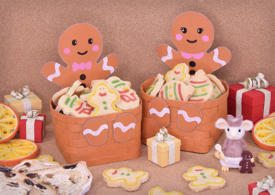 Lebkuchenmann und Lebkuchenfrau mit geflochtenen Körben voller Butterplätzchen, Fimo-Gustl von Mausbach und weihnachtlicher Dekoration – Papierkunst von Veronika Helga Vetter, Webkünstlerin seit 2012 Vor einem warmen, hellbraunen Korkhintergrund entfaltet sich eine Szenerie, die vor weihnachtlicher Lebensfreude fast zu tanzen scheint – ein kleines Bühnenstück aus Papier, Fimo und Gebäck, bei dem alles glänzt, duftet und leuchtet. Im Mittelpunkt stehen zwei Lebkuchenfiguren mit ihren geflochtenen Körben: links der Lebkuchenmann, rechts die Lebkuchenfrau, beide bis ins Detail identisch gestaltet. Ihr Tonpapier besitzt einen satten Sienna-Braun-Ton – ein feiner, erdiger Kontrast zu den hellen Butterplätzchen, die in ihren Körben liegen. Diese Plätzchen schimmern in cremigen Farbtönen zwischen Elfenbein und hellbraun. Ihre Ränder sind mit bunter Zuckerglasur verziert, wie man sie aus kleinen Dekorfläschchen kennt: leuchtend Gelb, tiefes Rot, festliches Grün – klassische Weihnachtsfarben, die sofort nach Vanille, Zucker und Kindheit riechen. Zwischen den süßen Formen finden sich auch Christbaumkugeln aus Butterteig, glasiert und liebevoll verziert, als wollten sie in Miniaturform den ganzen Weihnachtsbaum ersetzen. Rund um das zentrale Duo herrscht fröhliches Durcheinander aus festlicher Deko: winzige Geschenkverpackungen in Gold, Silber und Rot, glänzend, mit kleinen Schleifen verziert – die typischen Päckchen, die nach Filmklassik und Heiligabend riechen. Sie liegen verstreut, als wäre hier gerade eine kleine Bescherung im Gange. Auf der rechten Seite, gleich neben der Lebkuchenfrau, steht Gustl von Mausbach, der in dieser Szene als 17.-Jahrhundert-Lebzelter in Erscheinung tritt. Seine Figur aus Fimo trägt ein ledernes Hütchen und ein passendes Wams, darüber eine weiße Schürze, die ihn als fleißigen Zuckerbäcker ausweist. In seiner rechten Hand hält er einen winzigen Holzlöffel, in der linken stützt er einen dunklen Lebkuchenmann, der wie frisch aus dem Ofen gekommen wirkt – mit weißen Knopfaugen, gezuckertem Lächeln und feinen Zuckerpunkten als Knöpfe. Gustl selbst ist in hellem Ton gehalten, was seine Figur fast zum leuchtenden Mittelpunkt macht. An den Bildrändern, halb im Anschnitt, schimmern zwei kunstvolle Orangenscheiben – gefertigt in Quillingtechnik, in feinen Windungen aus Papier geformt, wie duftende Zitrussterne. Und ganz vorn links lugt ein echter Christstollen ins Bild: drei aufgeschnittene Scheiben, goldbraun, durchzogen von Rosinen und gehackten Nüssen. Dieses Arrangement wirkt wie ein liebevoll gedeckter Weihnachtstisch im Miniaturformat – voller Farbe, Bewegung und Duft. Die Komposition fängt den Geist der Adventszeit ein: Fülle, Handarbeit, Sinnlichkeit. Das Werk stammt von Veronika Helga Vetter, österreichische Papier- und Webkünstlerin seit 2012, deren Blick für Struktur, Farbe und Komposition aus Alltagsmaterialien poetische Weihnachtswelten entstehen lässt – warm, detailverliebt und mit einem Augenzwinkern handwerklicher Perfektion. GWS2.de